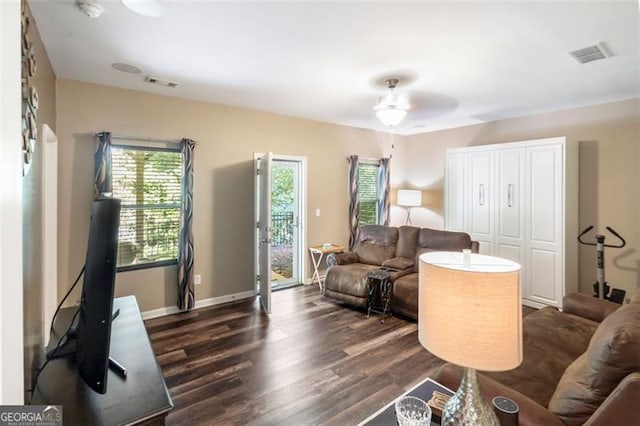 living room with ceiling fan and dark wood-type flooring