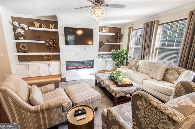 living room with built in features, ceiling fan, ornamental molding, and a premium fireplace