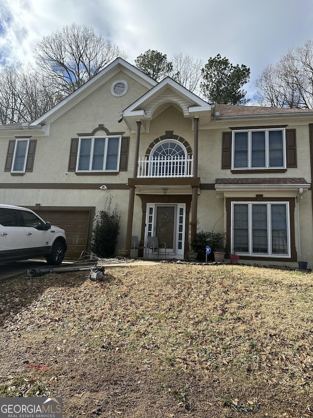 view of front property featuring a garage and a balcony