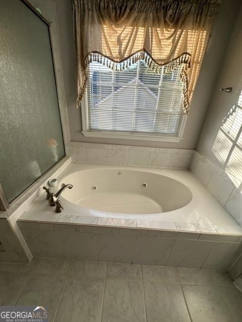 bathroom featuring tile patterned flooring and tiled bath