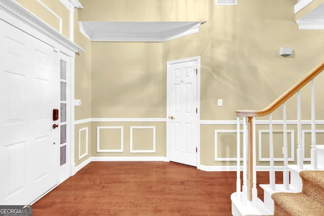 foyer entrance featuring crown molding and hardwood / wood-style flooring