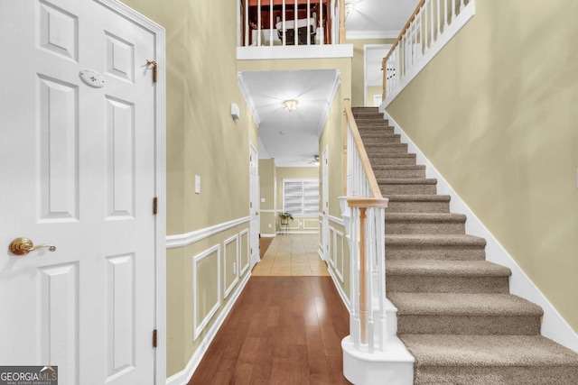 foyer featuring hardwood / wood-style flooring, ceiling fan, and crown molding