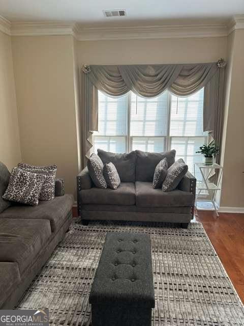 living room with crown molding, a healthy amount of sunlight, and dark hardwood / wood-style floors