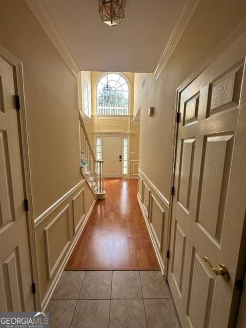 hall with light tile patterned floors and ornamental molding