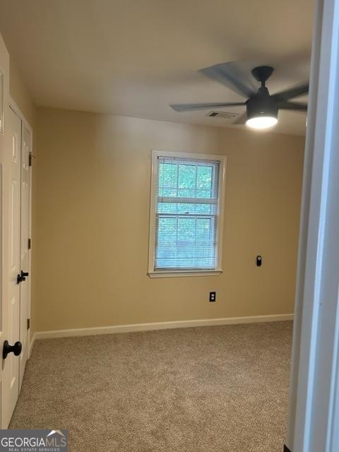 unfurnished room featuring light carpet and ceiling fan