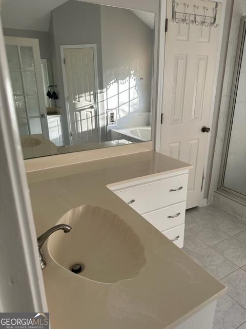 bathroom with tile patterned floors, a shower with door, and vanity