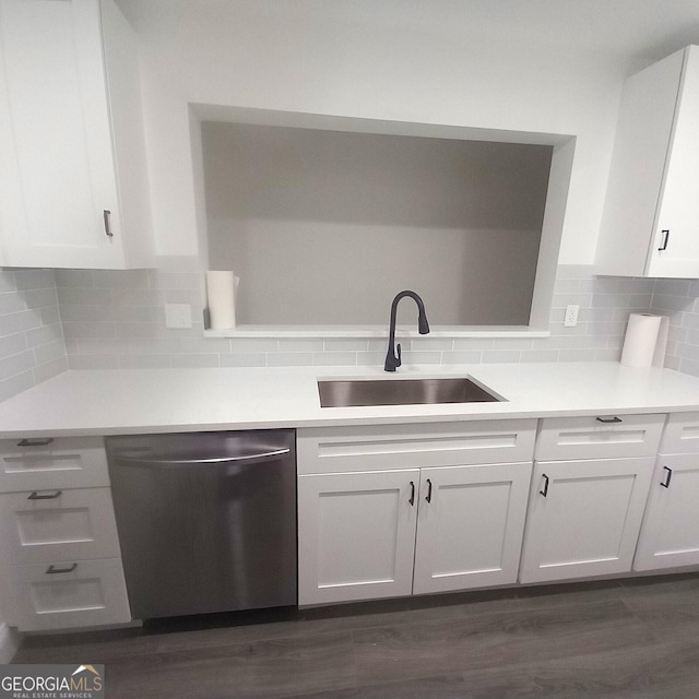 kitchen with sink, stainless steel dishwasher, dark hardwood / wood-style floors, decorative backsplash, and white cabinets