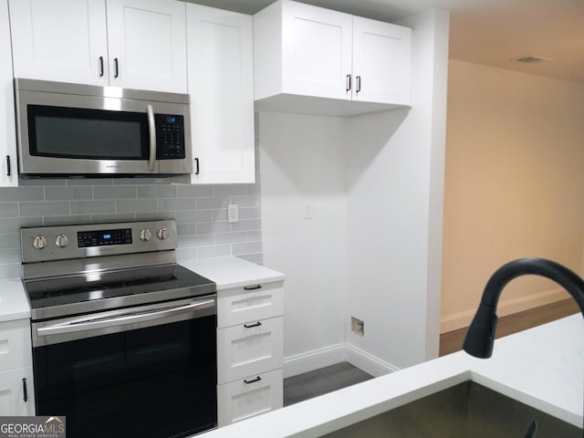 kitchen featuring white cabinetry, backsplash, and appliances with stainless steel finishes