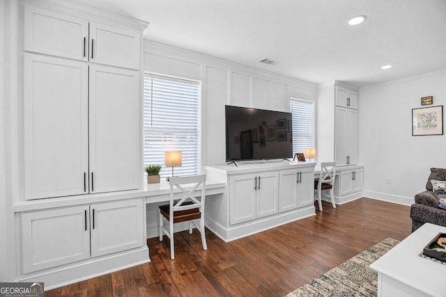 living room featuring built in desk, dark wood-type flooring, a wealth of natural light, and ornamental molding