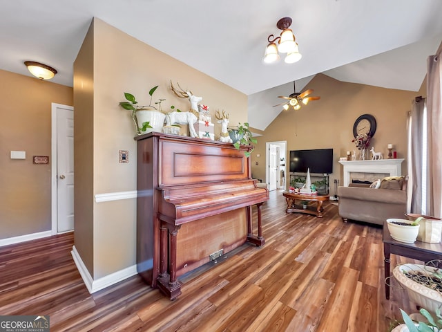 misc room featuring ceiling fan with notable chandelier, hardwood / wood-style flooring, and lofted ceiling