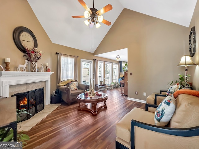 living room with a tile fireplace, hardwood / wood-style flooring, high vaulted ceiling, and ceiling fan