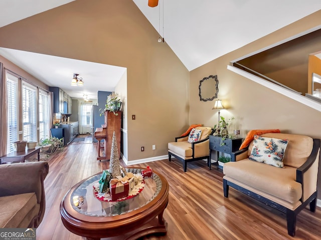 living room featuring ceiling fan, wood-type flooring, and lofted ceiling