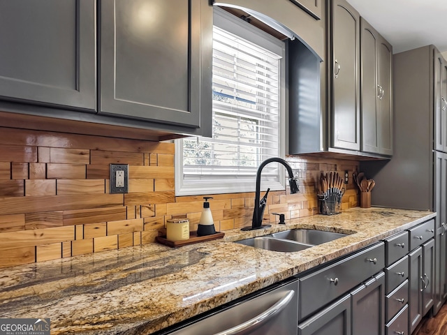 kitchen featuring gray cabinets, light stone counters, plenty of natural light, and sink