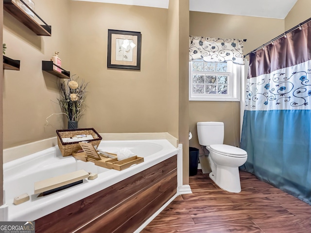 bathroom with a tub, wood-type flooring, and toilet