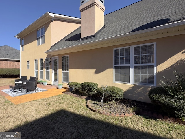 back of property with a lawn and a patio area