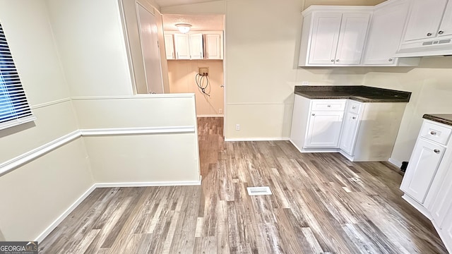 kitchen featuring light wood-type flooring and white cabinetry