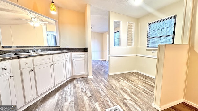 bathroom featuring ceiling fan, wood-type flooring, a textured ceiling, and vanity