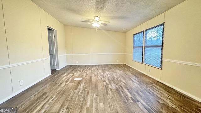 empty room with hardwood / wood-style floors, ceiling fan, and a textured ceiling