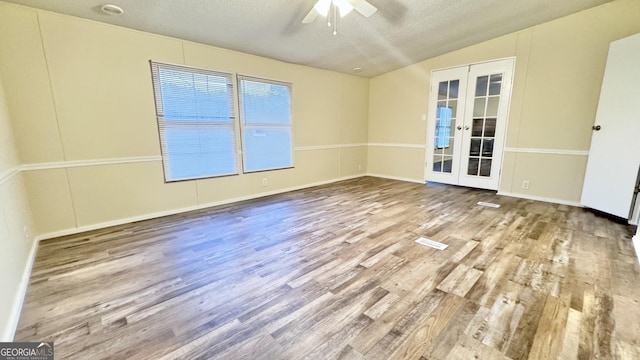 unfurnished room featuring ceiling fan, french doors, wood-type flooring, lofted ceiling, and a textured ceiling