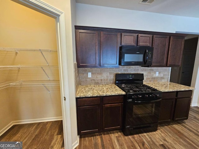 kitchen with backsplash, dark hardwood / wood-style flooring, dark brown cabinets, and black appliances