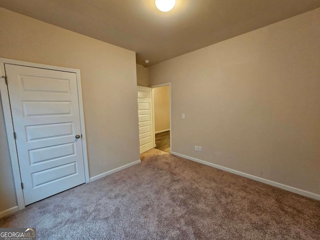 unfurnished bedroom with light carpet and a closet