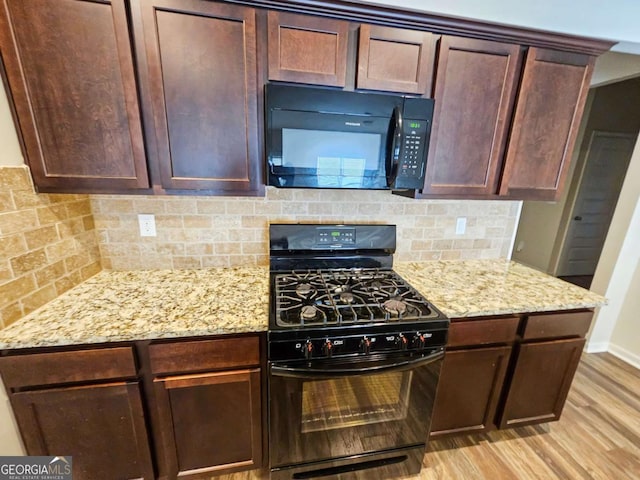 kitchen with black appliances, tasteful backsplash, dark brown cabinets, light hardwood / wood-style floors, and light stone counters