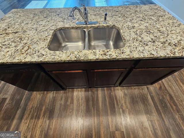 details with light stone countertops, dark brown cabinets, and sink