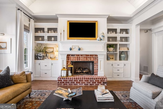 living room with crown molding, dark hardwood / wood-style flooring, lofted ceiling, and a fireplace