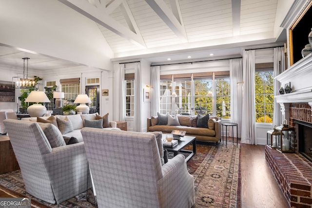 living room with dark hardwood / wood-style flooring, beamed ceiling, a fireplace, a chandelier, and high vaulted ceiling