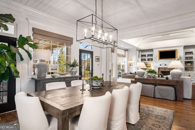 dining area with dark hardwood / wood-style flooring, wood ceiling, a chandelier, and ornamental molding