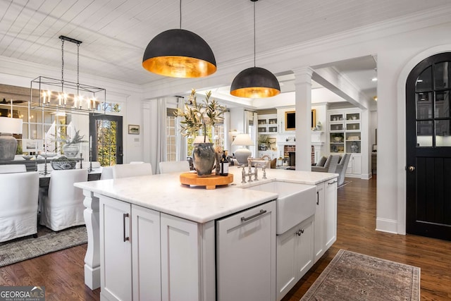 kitchen featuring a kitchen island with sink, dishwasher, pendant lighting, white cabinets, and sink