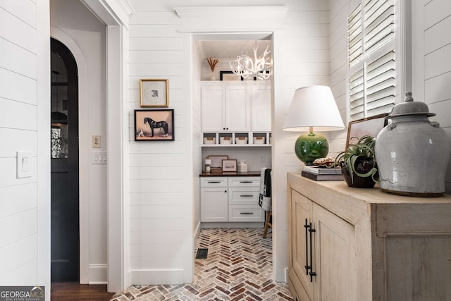 hall featuring wooden walls