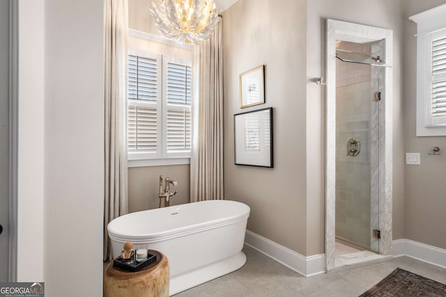 bathroom with a chandelier, tile patterned floors, and separate shower and tub