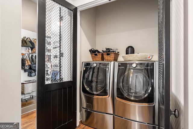 laundry area featuring hardwood / wood-style flooring and washing machine and clothes dryer