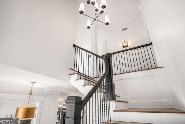 stairway with a notable chandelier