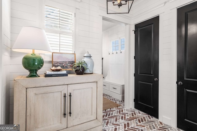 interior space with crown molding, a healthy amount of sunlight, and wooden walls