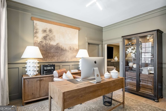 office with light hardwood / wood-style floors and crown molding