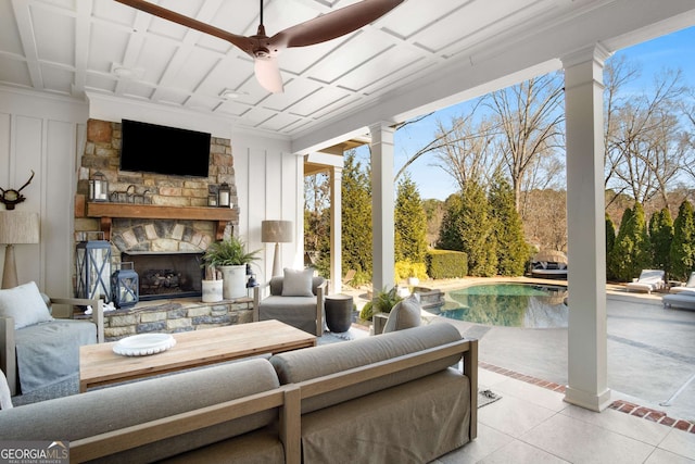 interior space with ceiling fan and an outdoor living space with a fireplace