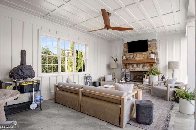 living room with ceiling fan and a fireplace