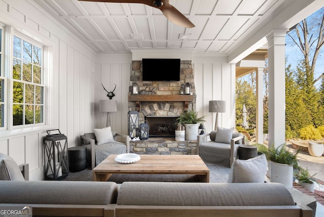 interior space with ceiling fan and a stone fireplace