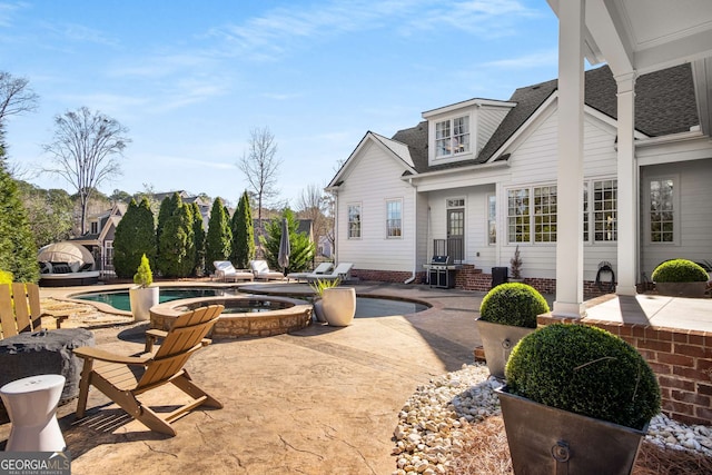 view of patio / terrace featuring a pool with hot tub