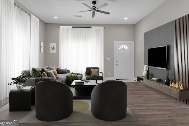 living room with hardwood / wood-style floors, ceiling fan, and plenty of natural light