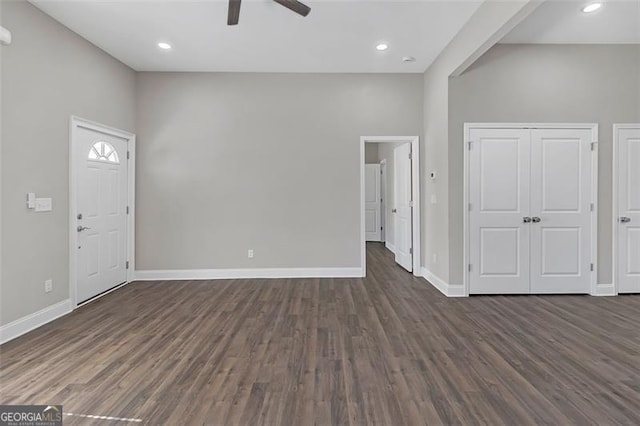 entryway with ceiling fan, dark hardwood / wood-style flooring, and a high ceiling