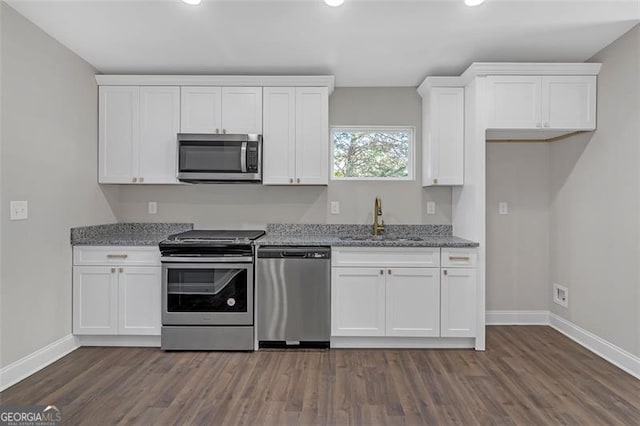 kitchen featuring white cabinetry, sink, light stone counters, and appliances with stainless steel finishes