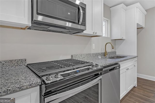 kitchen featuring sink, light stone counters, white cabinetry, and stainless steel appliances