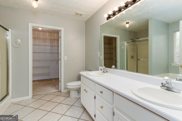 bathroom with an enclosed shower, vanity, a textured ceiling, tile patterned flooring, and toilet