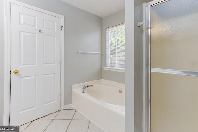 bathroom featuring tile patterned flooring and shower with separate bathtub