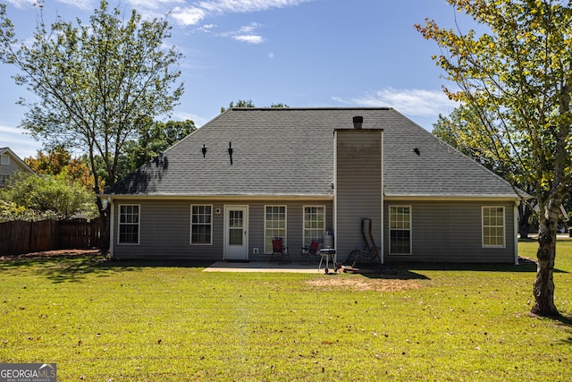 rear view of house with a patio area and a lawn