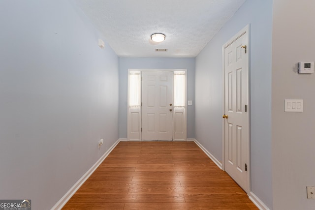 doorway to outside with hardwood / wood-style floors and a textured ceiling