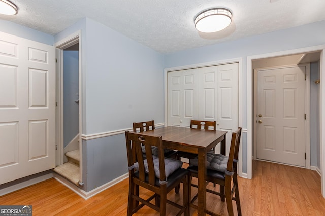 dining room featuring a textured ceiling and light hardwood / wood-style flooring